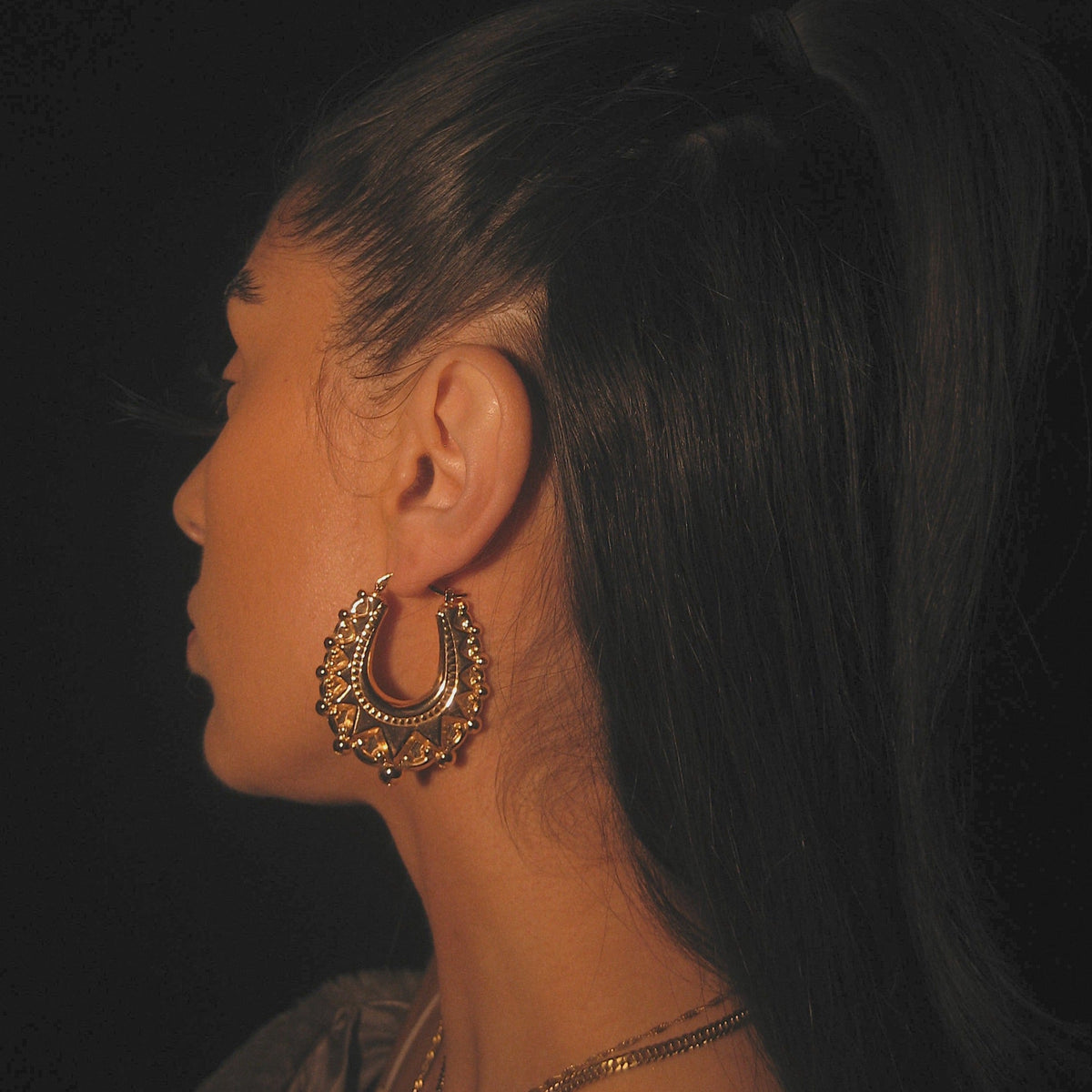 Model wearing gold Creole Hoops
